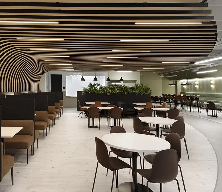 Large sports bar and lounge with curved bar, multiple screens, and wood slat ceiling